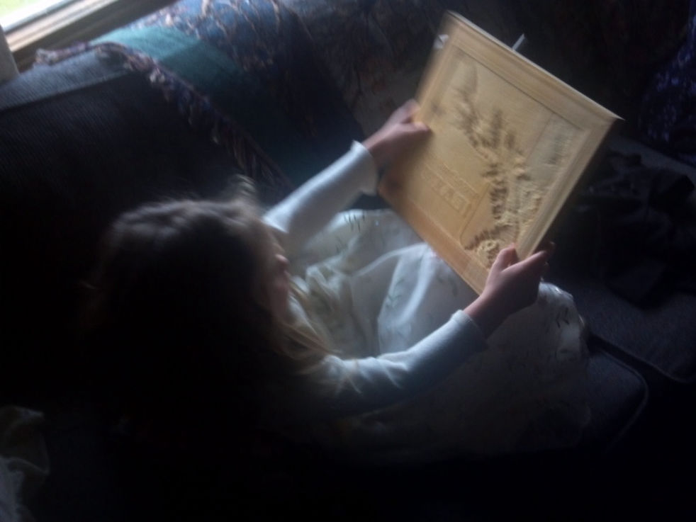 Young lady holding and looking at wooden map.